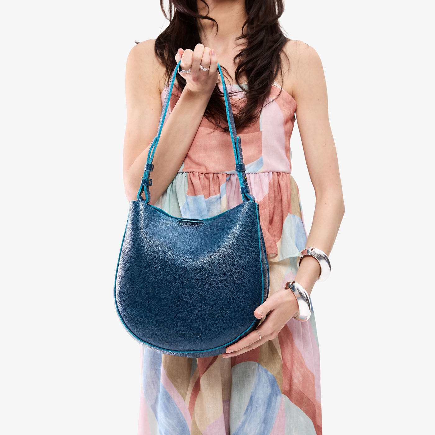 Caspian*Medium | Model holding round leather purse with adjustable shoulder strap