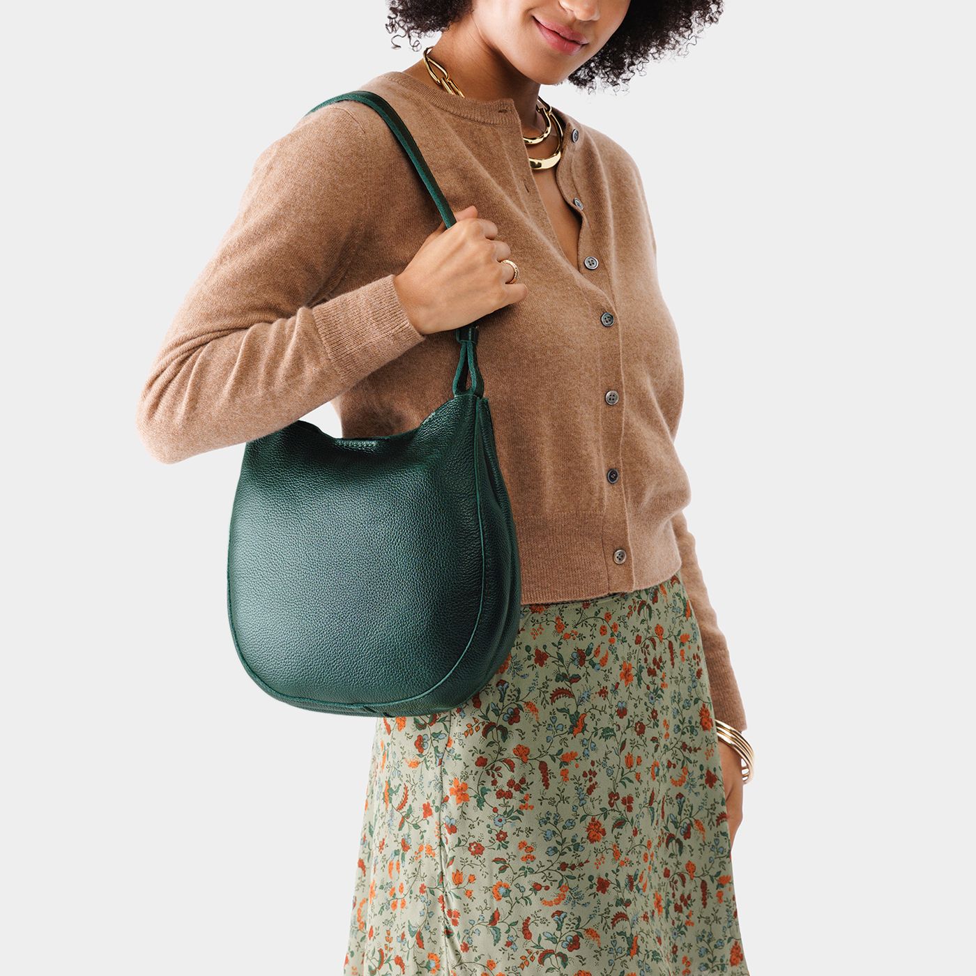 Forest Green*Medium | Woman wearing rounded shoulder bag with adjustable strap on a white background