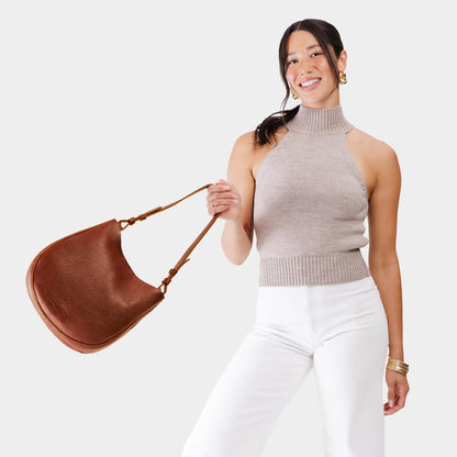 Nutmeg*Medium | Woman wearing rounded shoulder bag with adjustable strap on a white background