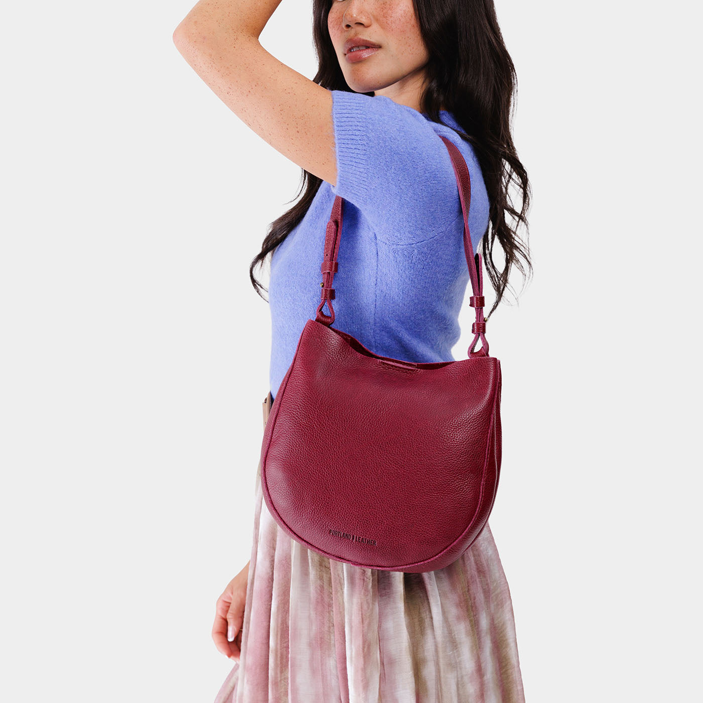 Orchid*Medium | Woman wearing rounded shoulder bag with adjustable strap on a white background