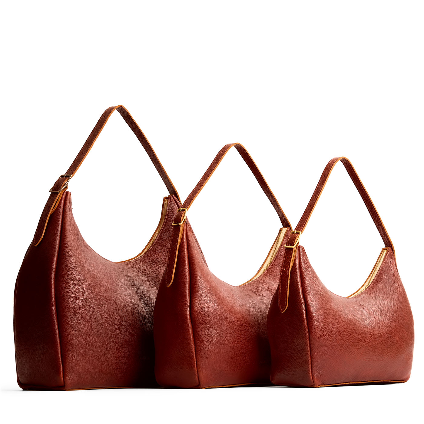 Nutmeg | Size comparison image of oversized, large, and medium u-shaped, flat-bottomed leather shoulder bags with adjustable strap