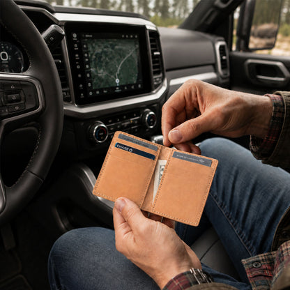 Naturale | A person sitting inside a vehicle holding an open card holder