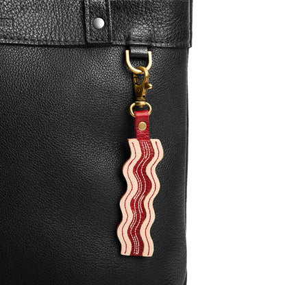 Pancetta | Keychain shaped like a strip of bacon with a swivel lobster clasp on a bag