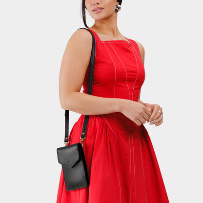 Pebbled--black | Model wearing slim, phone-shaped crossbody purse with magnetic closure