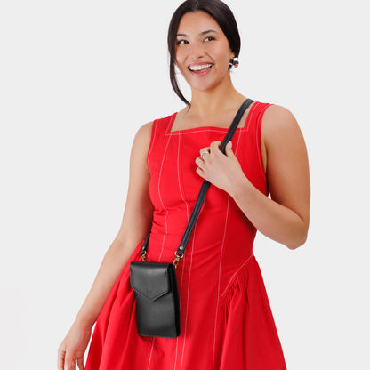 Pebbled--black | Model wearing slim, phone-shaped crossbody purse with magnetic closure