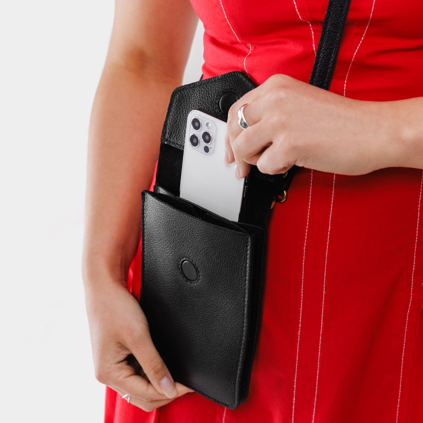 Pebbled--black | Model wearing slim, phone-shaped crossbody purse with magnetic closure