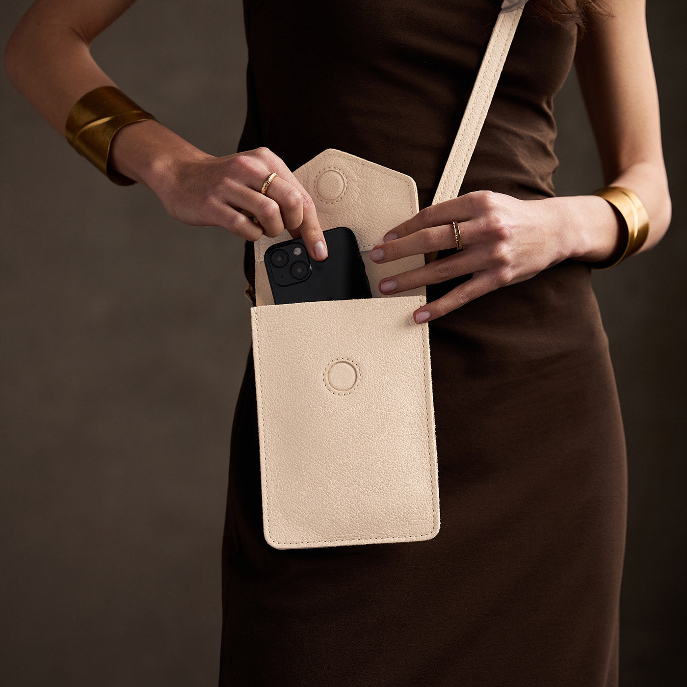 Pebbled Bone | Model wearing slim, phone-shaped crossbody purse with magnetic closure