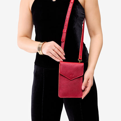 Reba Red | Model wearing slim, phone-shaped crossbody purse with magnetic closure