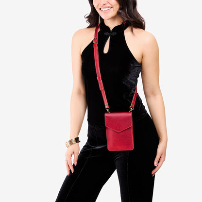 Reba Red | Model wearing slim, phone-shaped crossbody purse with magnetic closure
