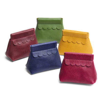 Five small pebbled leather pouches with scalloped flap edges arranged on a white background.