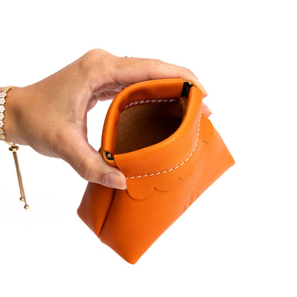 Clementine | Hand holding leather coin pouch with scalloped edge and three Portland leather tree emblems open