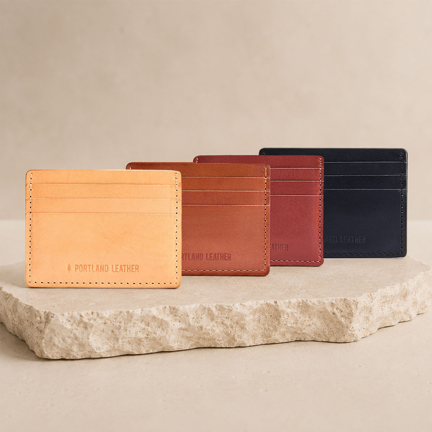 Marrone | Group of wallets arranged in a row on a light colored stone slab