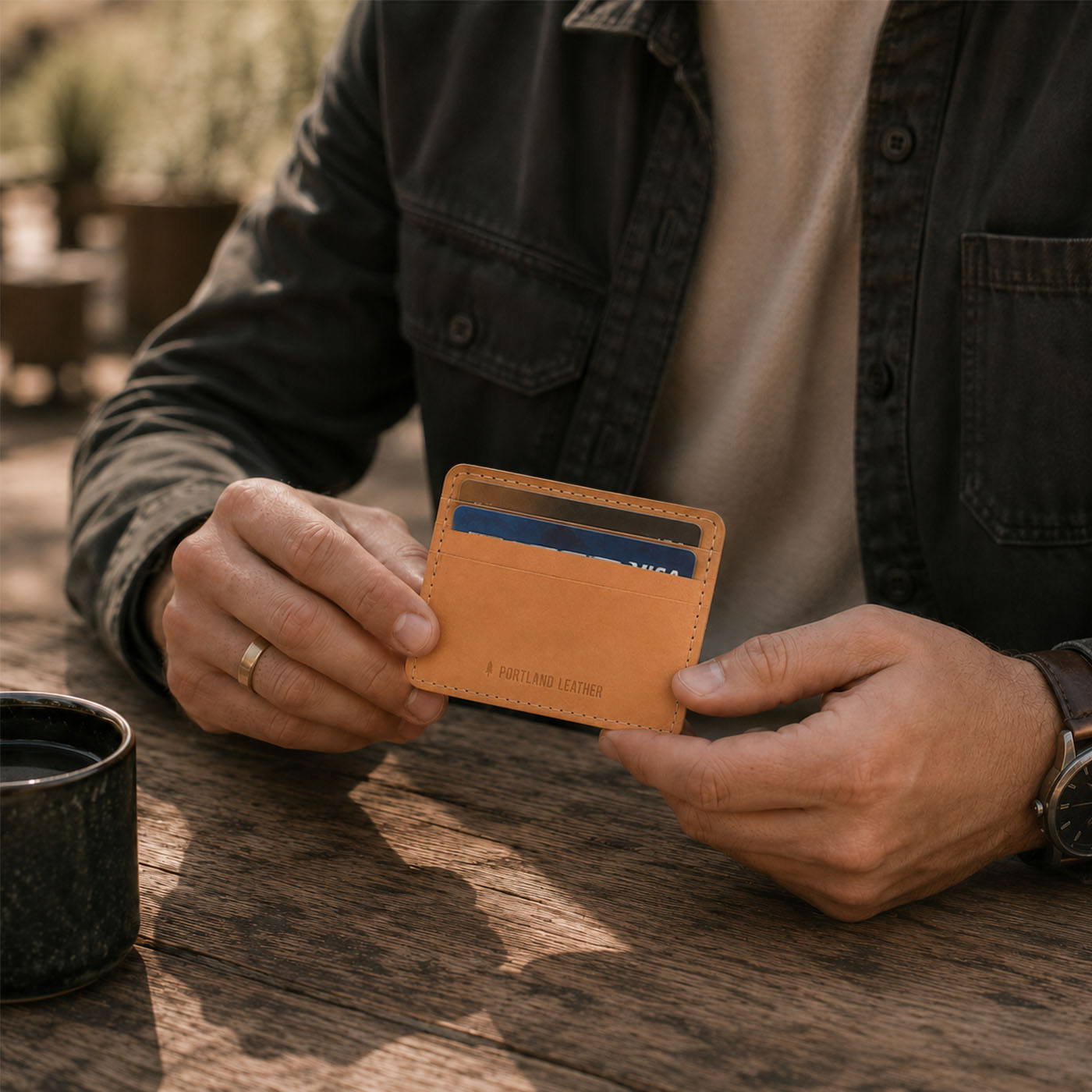 Naturale | A close-up lifestyle shot of a model holding a leather card holder