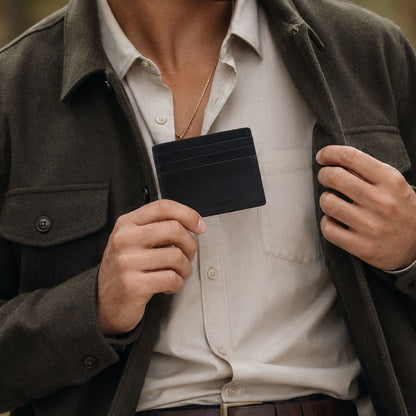 Nero | A close-up lifestyle shot of a model holding a leather card holder
