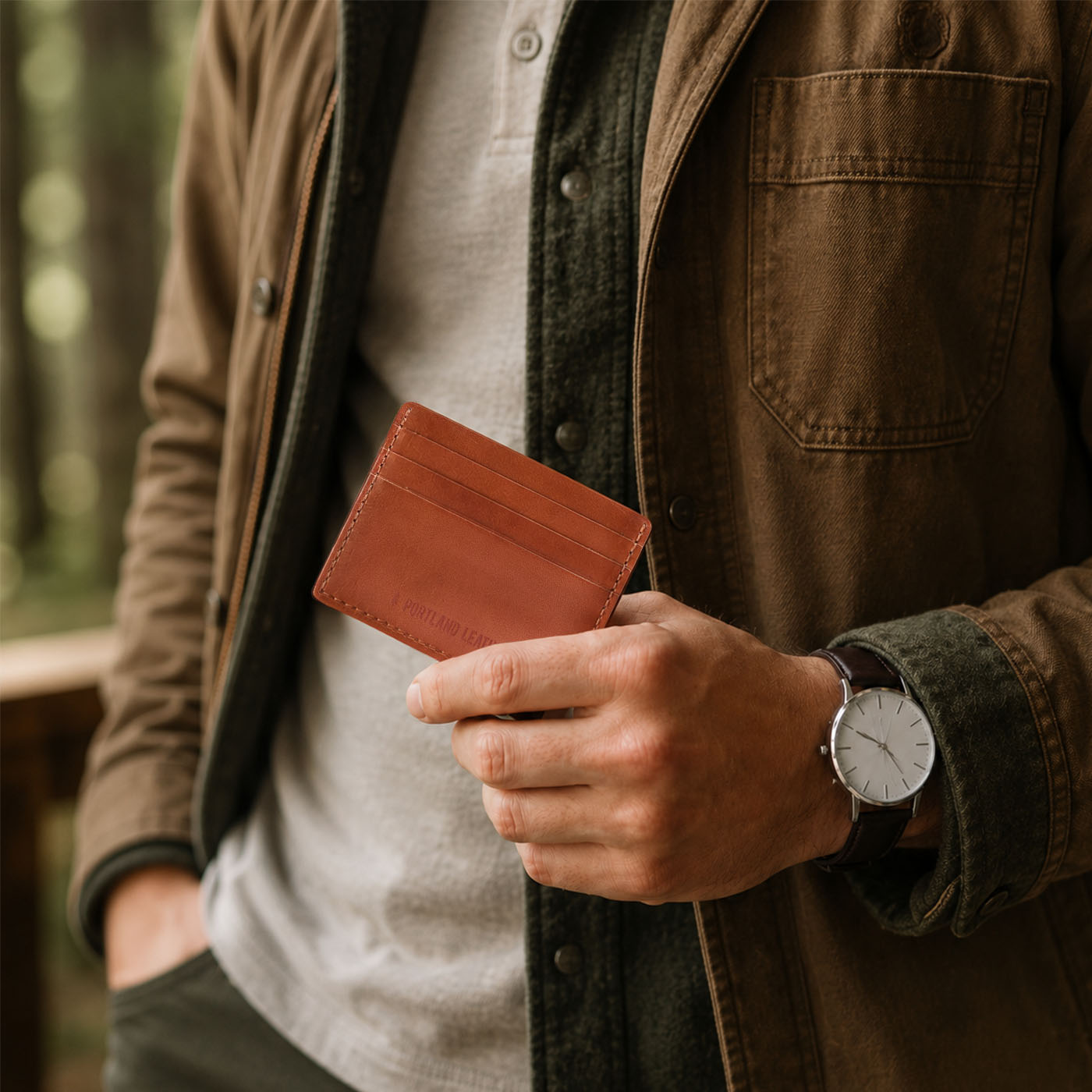 Toscano | A close-up lifestyle shot of a model holding a leather card holder