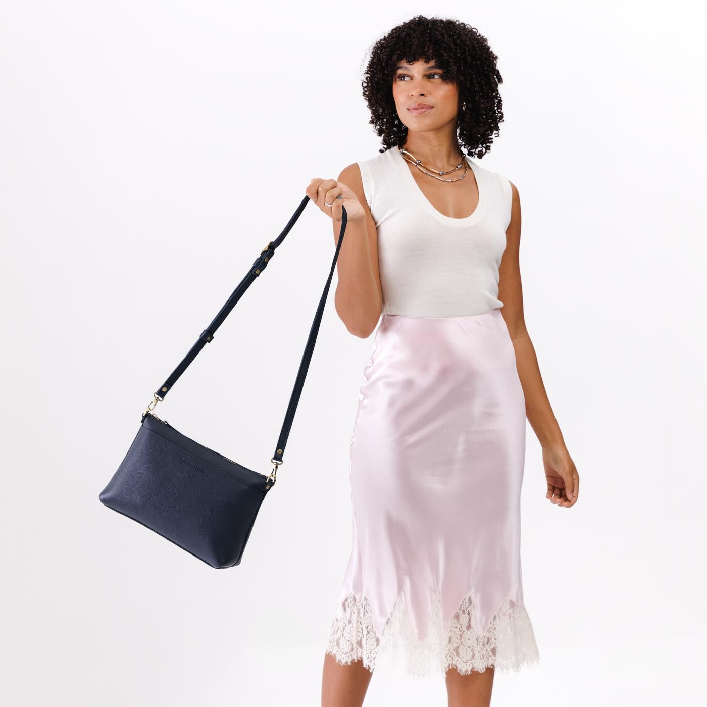 Night Owl*Large | A Model holding a zip top crossbody bag with detachable strap