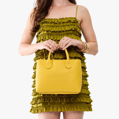 Canary*Large | Model holding a mid-size tote purse with structured leather handles and crossbody strap