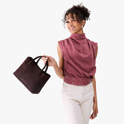 Velvet Brown*Large | Model holding mid-size tote purse with structured leather handles and crossbody strap