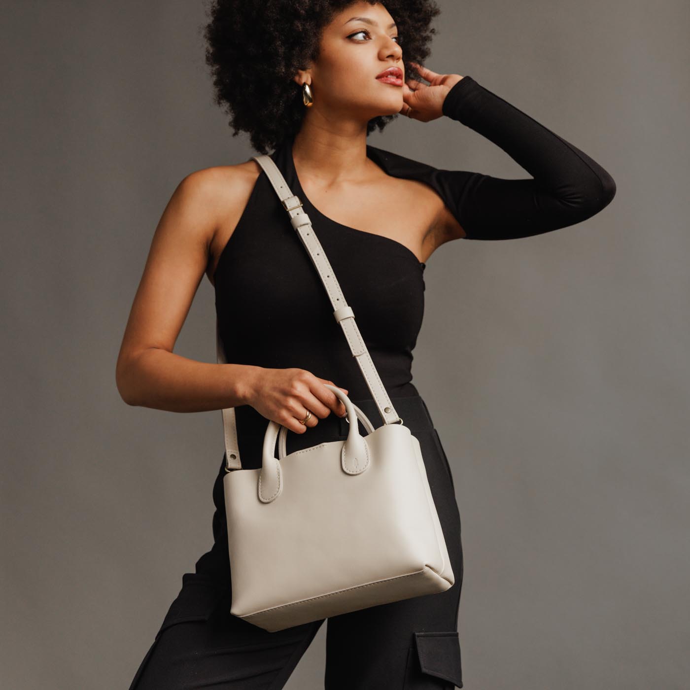 Bone*Large | Model holding mid-size tote purse with structured leather handles and crossbody strap
