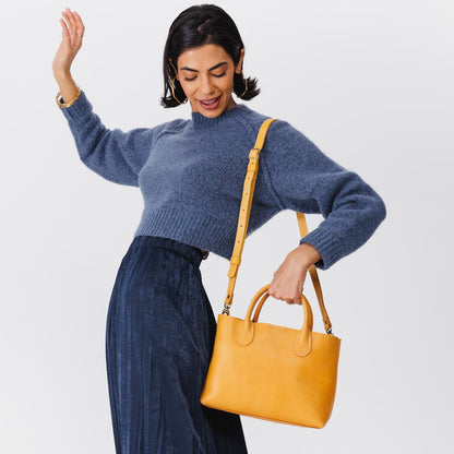Sunflower*Large | Model holding mid-size tote purse with structured leather handles and crossbody strap