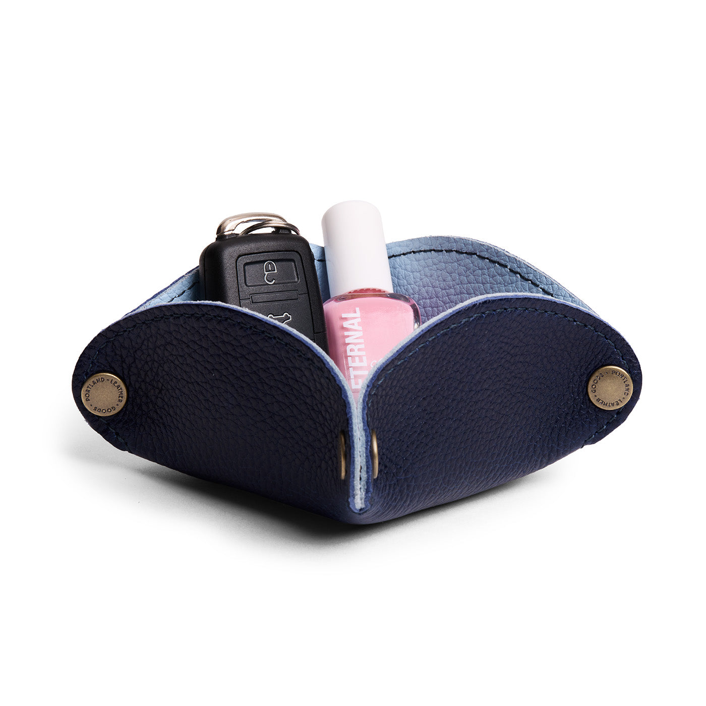 Cobalt | Square-shaped foldable leather tray with snap-button corners holding car keys and nail polish