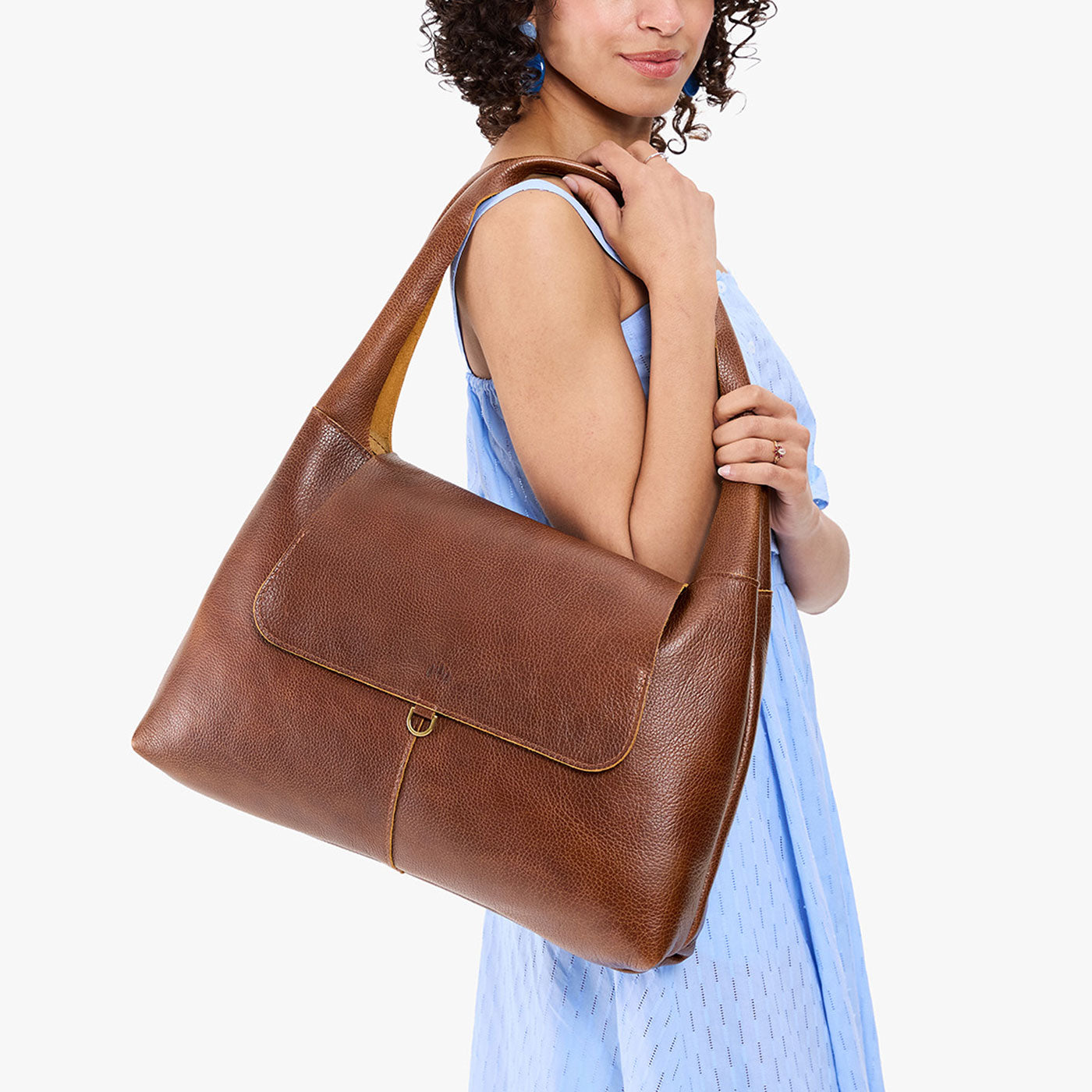 Asheville*Large | A model holding a slouchy triangle shaped shoulder bag with a flap