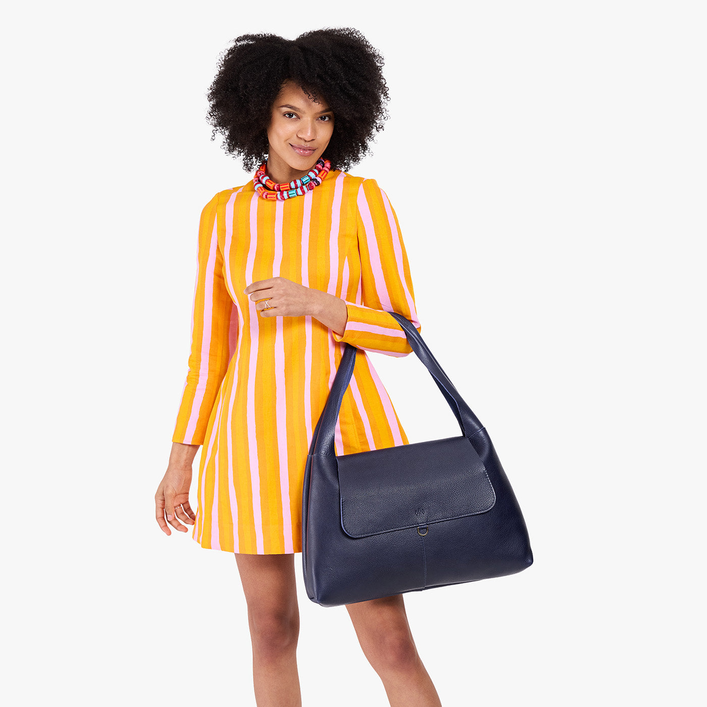 Cobalt*Large | A model holding a slouchy triangle shaped shoulder bag with a flap