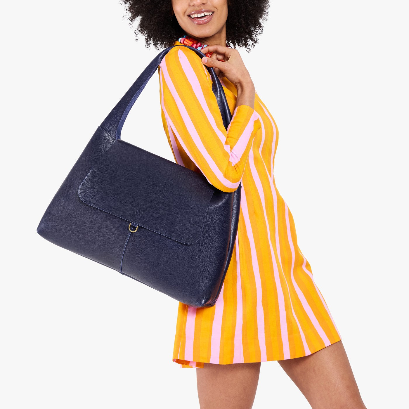 Cobalt*Large | A model holding a slouchy triangle shaped shoulder bag with a flap