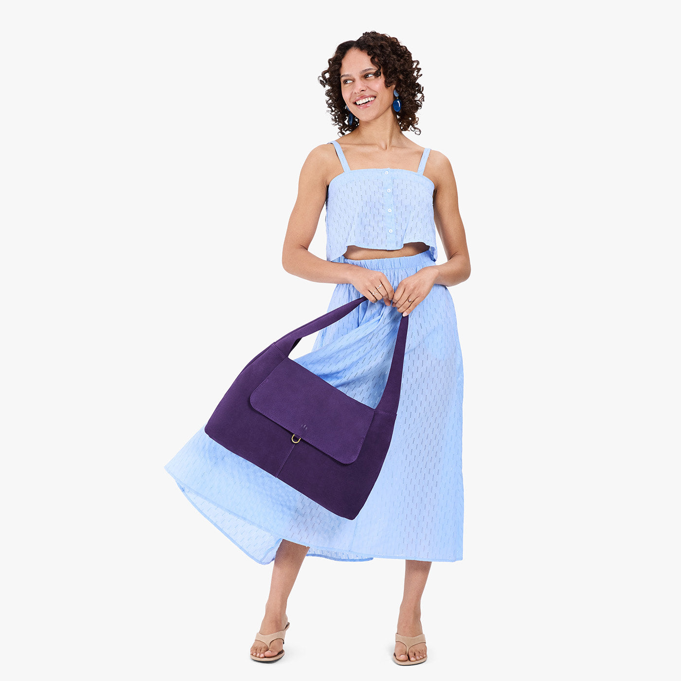 Imperial*Large | A model holding a slouchy triangle shaped shoulder bag with a flap