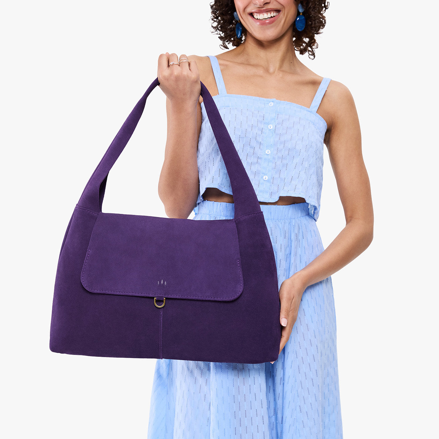 Imperial*Large | A model holding a slouchy triangle shaped shoulder bag with a flap