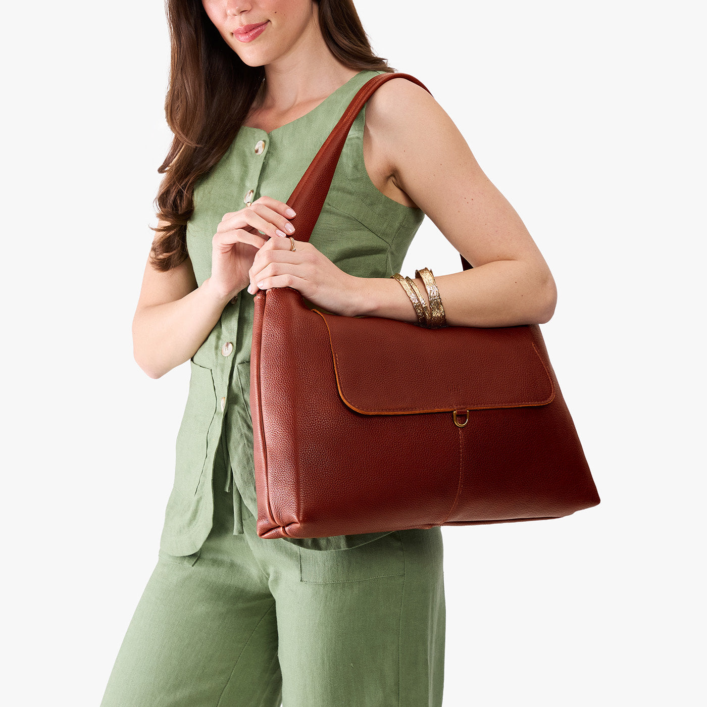 Nutmeg*Large | A model holding a slouchy triangle shaped shoulder bag with a flap