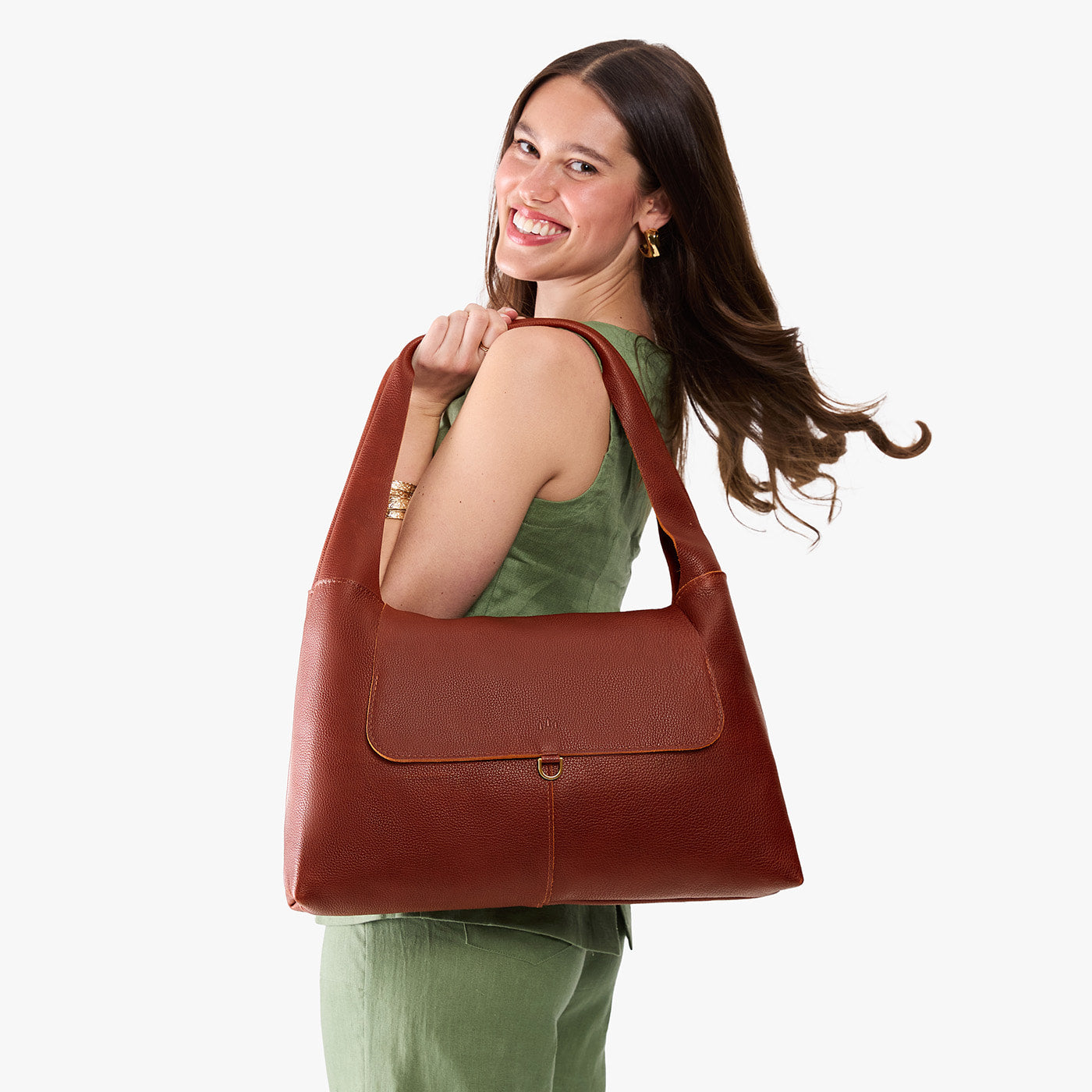 Nutmeg*Large | A model holding a slouchy triangle shaped shoulder bag with a flap