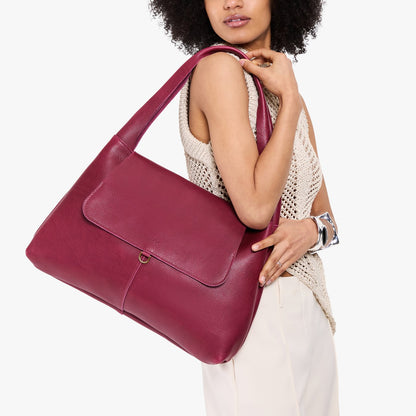 Orchid*Large | A model holding a slouchy triangle shaped shoulder bag with a flap