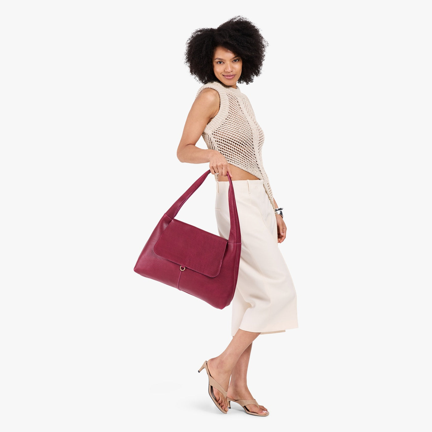 Orchid*Large | A model holding a slouchy triangle shaped shoulder bag with a flap