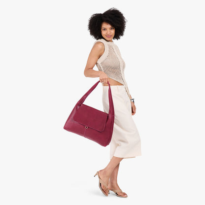 Orchid*Large | A model holding a slouchy triangle shaped shoulder bag with a flap