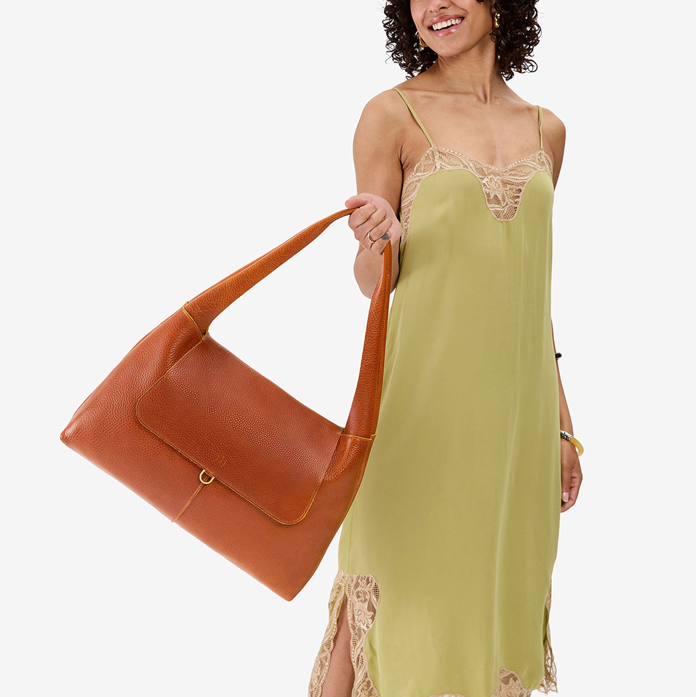 Sienna*Large | A model holding a slouchy triangle shaped shoulder bag with a flap