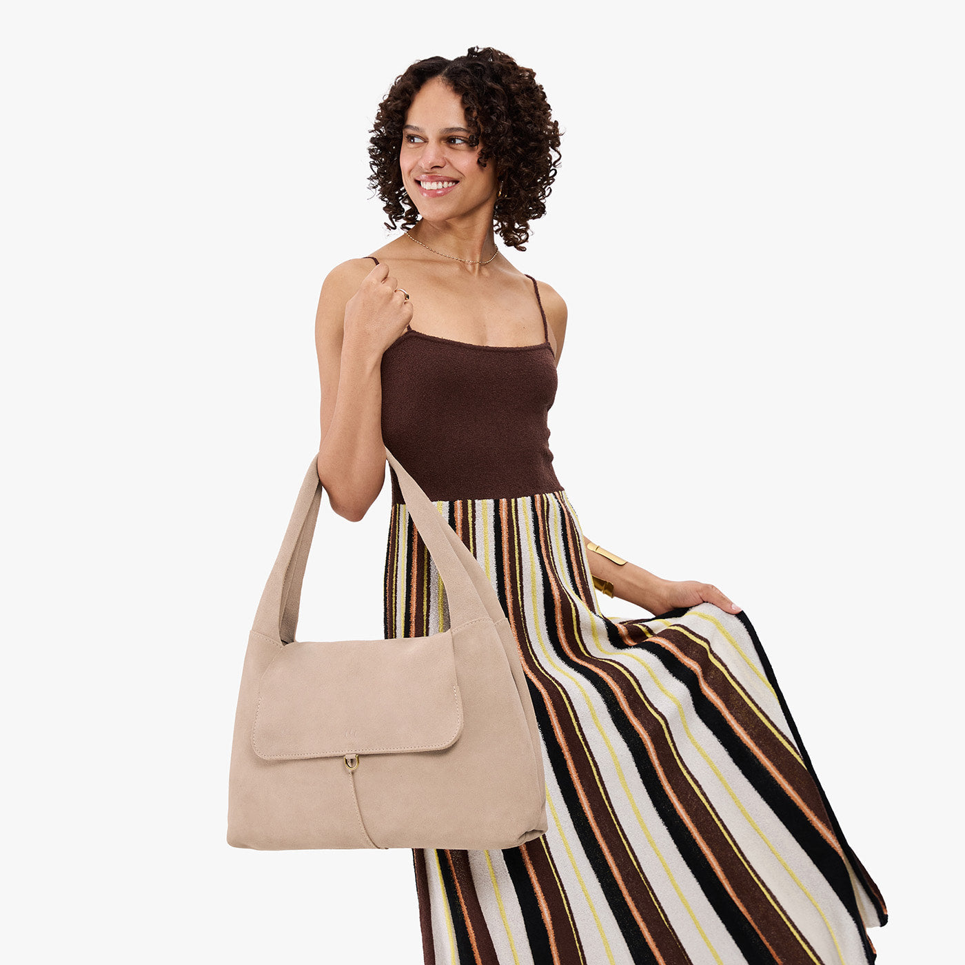 Taupe*Large | A model holding a slouchy triangle shaped shoulder bag with a flap