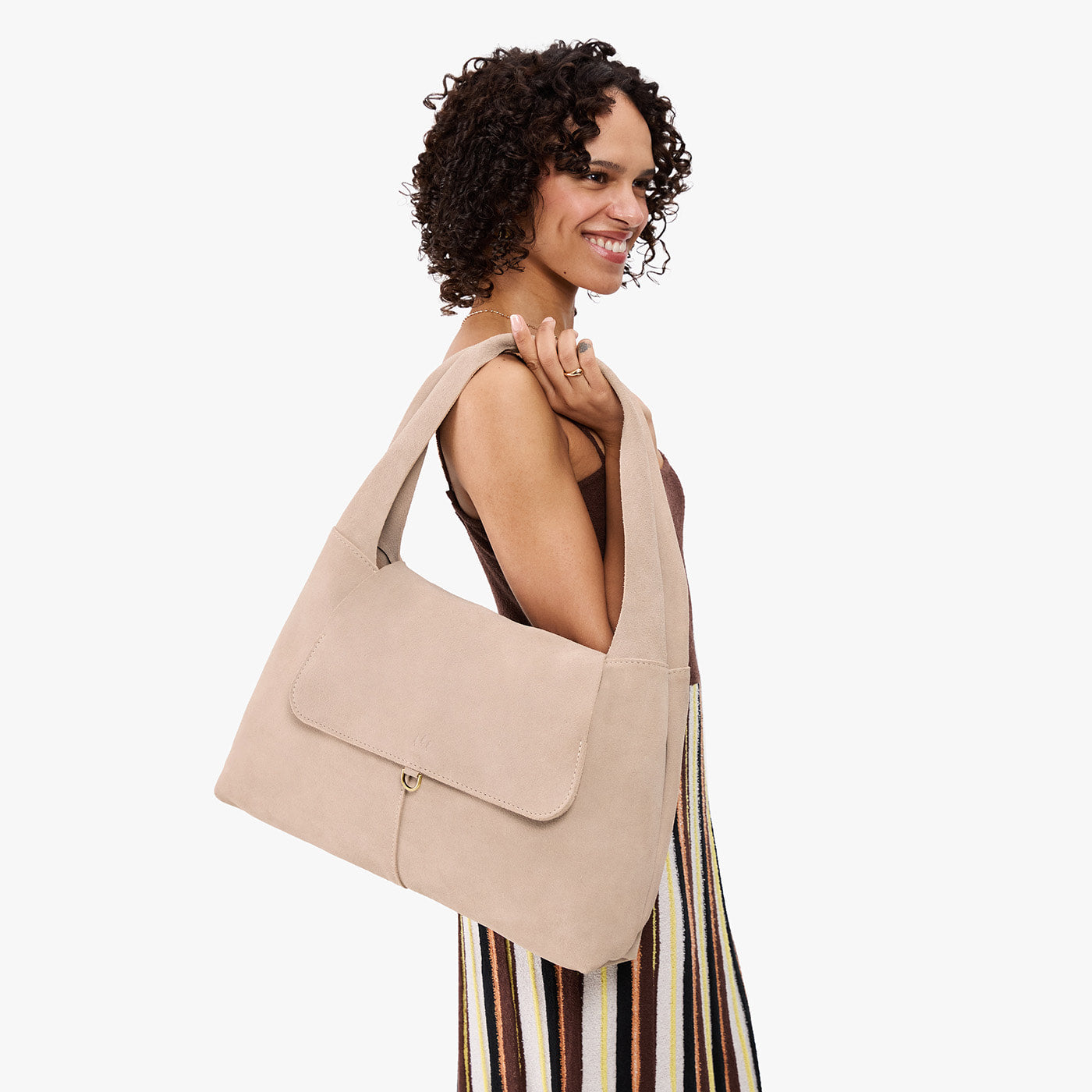 Taupe*Large | A model holding a slouchy triangle shaped shoulder bag with a flap