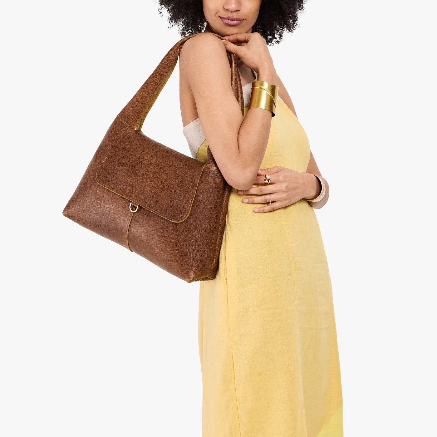 Asheville*Medium | A model holding a slouchy triangle shaped shoulder bag with a flap