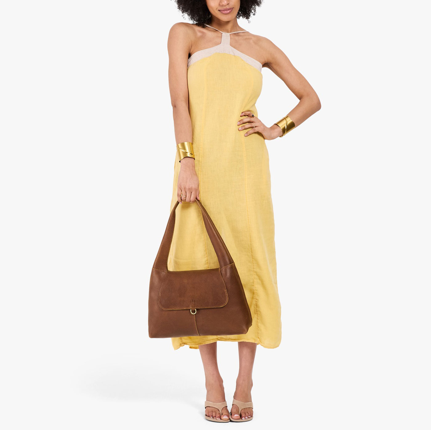 Asheville*Medium | A model holding a slouchy triangle shaped shoulder bag with a flap