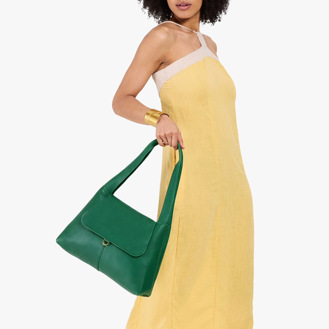 Bacalar*Medium | A model holding a slouchy triangle shaped shoulder bag with a flap