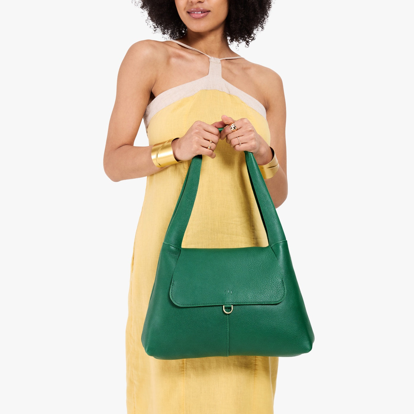 Bacalar*Medium | A model holding a slouchy triangle shaped shoulder bag with a flap