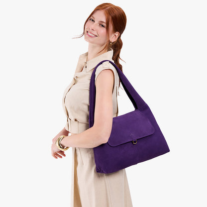 Imperial*Medium | A model holding a slouchy triangle shaped shoulder bag with a flap
