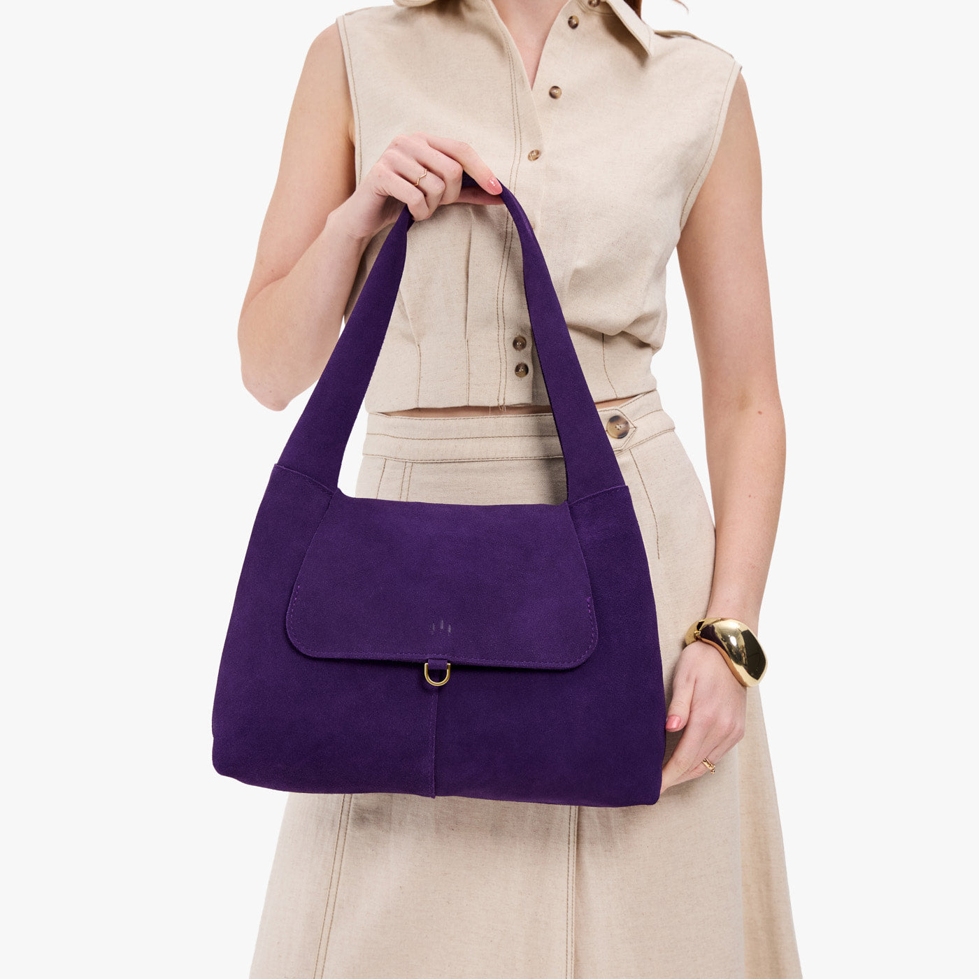 Imperial*Medium | A model holding a slouchy triangle shaped shoulder bag with a flap