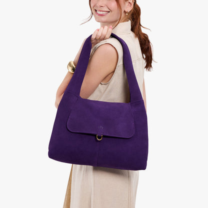 Imperial*Medium | A model holding a slouchy triangle shaped shoulder bag with a flap
