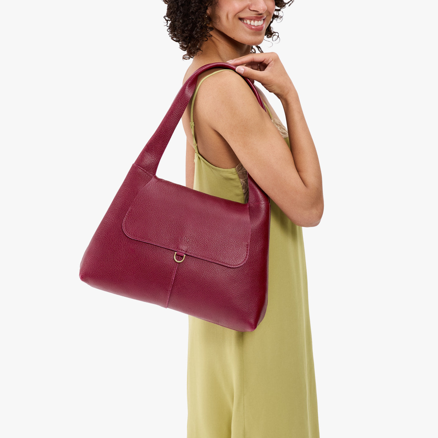 Orchid*Medium | A model holding a slouchy triangle shaped shoulder bag with a flap