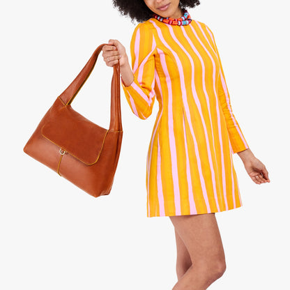Sienna*Medium | A model holding a slouchy triangle shaped shoulder bag with a flap
