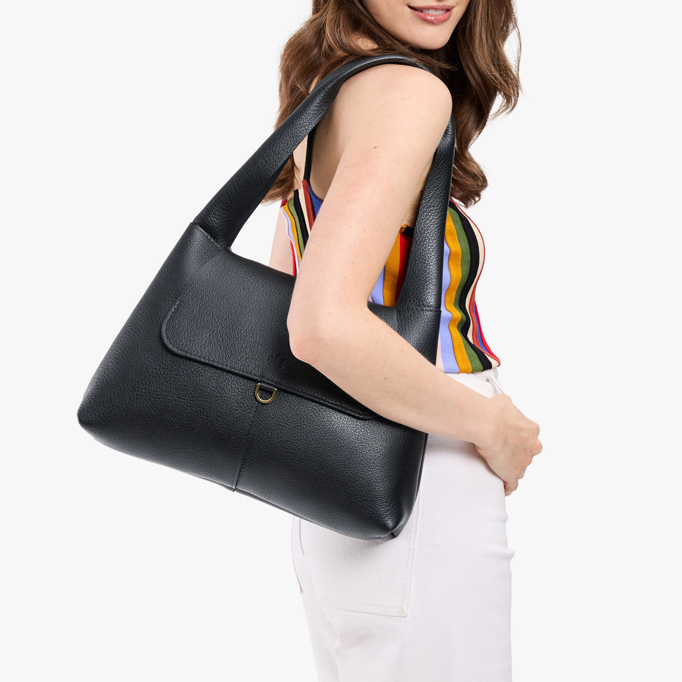 Pebbled--black*Medium | A model holding a slouchy triangle shaped shoulder bag with a flap
