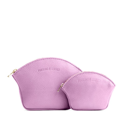 Calla Lily | Comparison shot of small and large seashell shaped leather makeup bags with curved top zipper and flat bottom