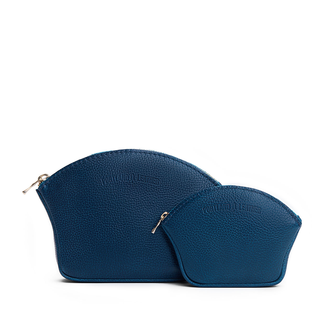 Caspian | Comparison shot of small and large seashell shaped leather makeup bags with curved top zipper and flat bottom